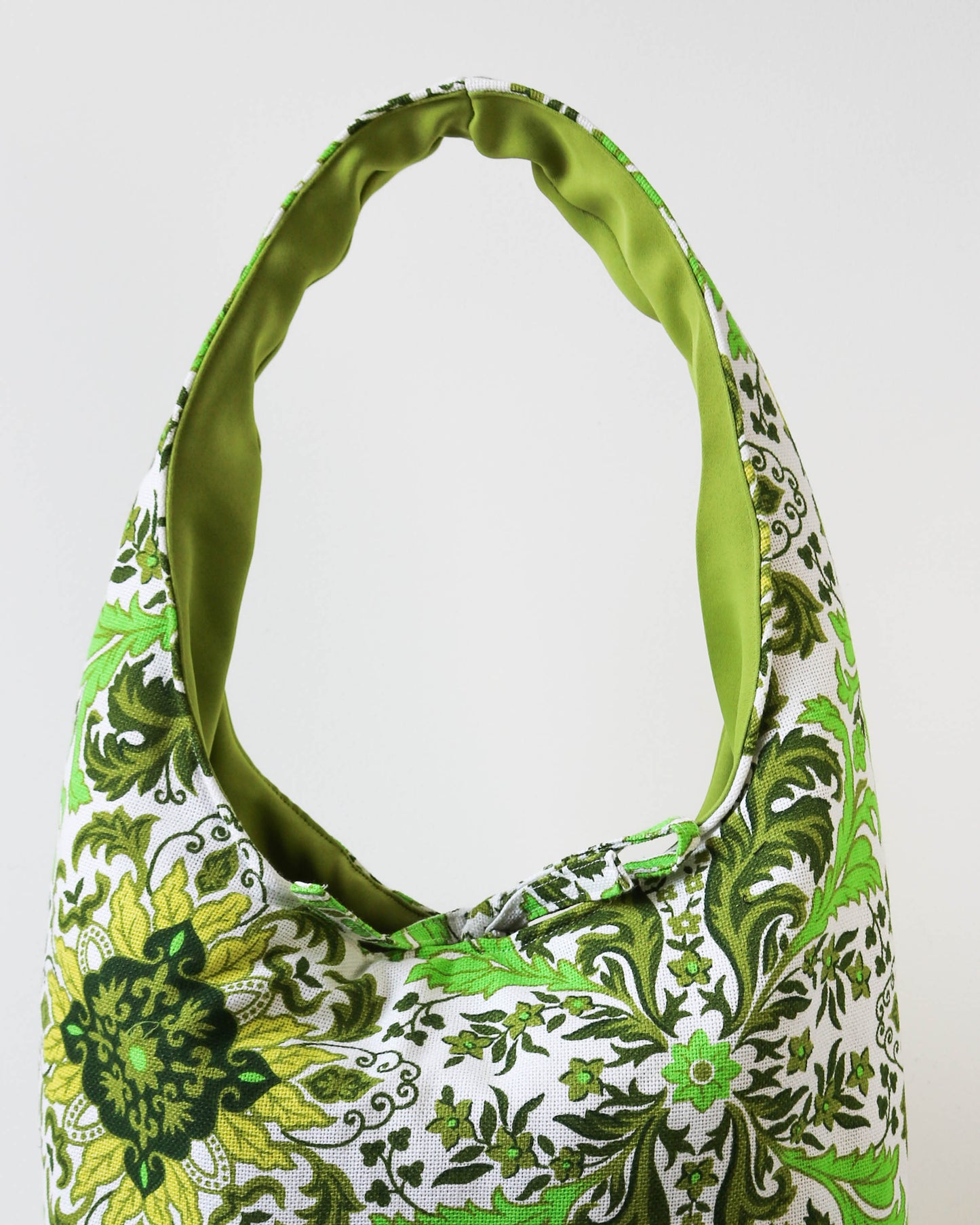 Green and white patterned handbag on a white background