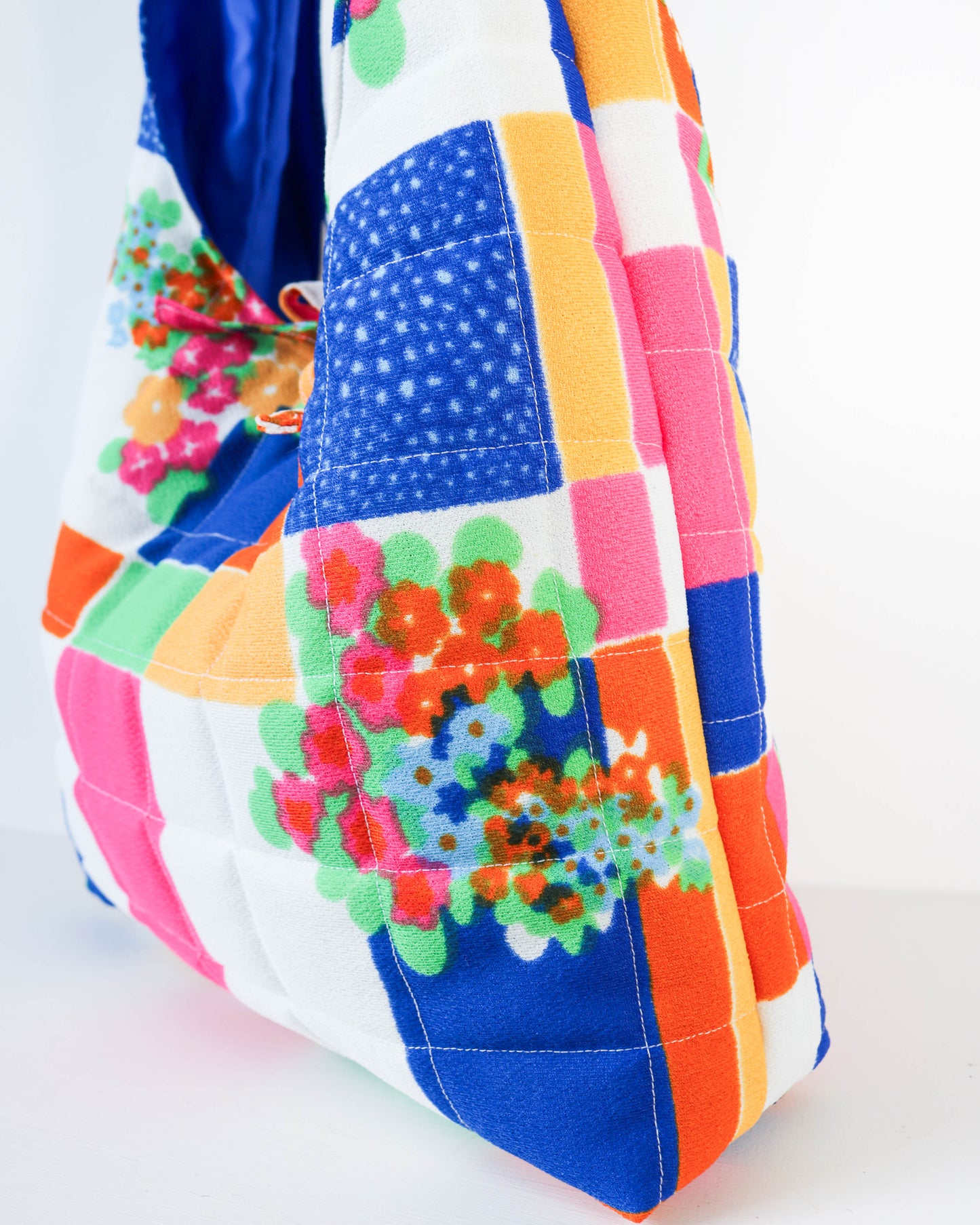 Colorful quilt with floral patterns on a white background