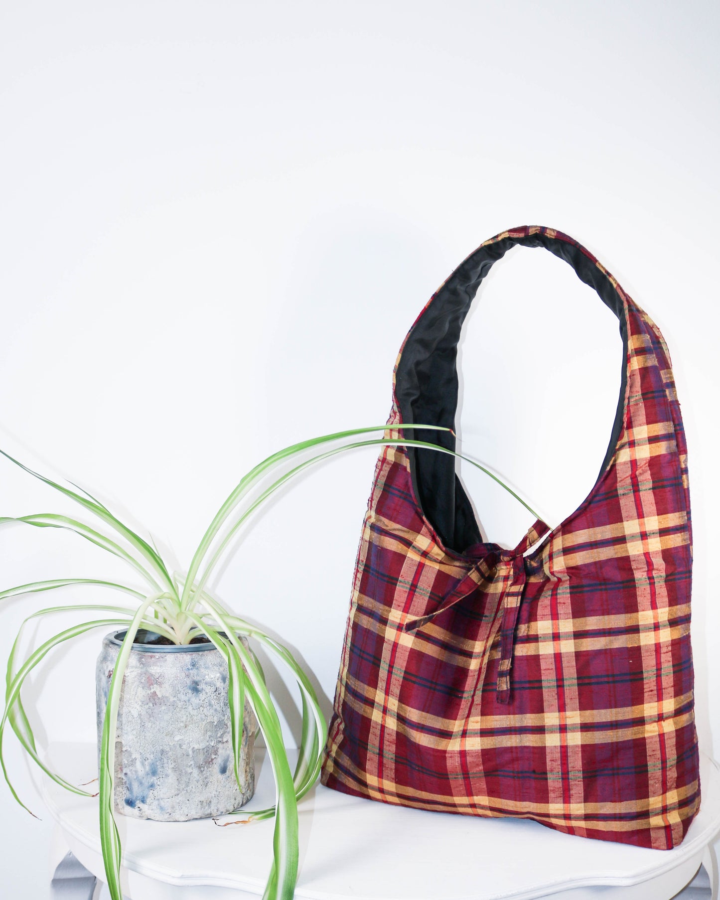 Plaid bag with a plant on a white background