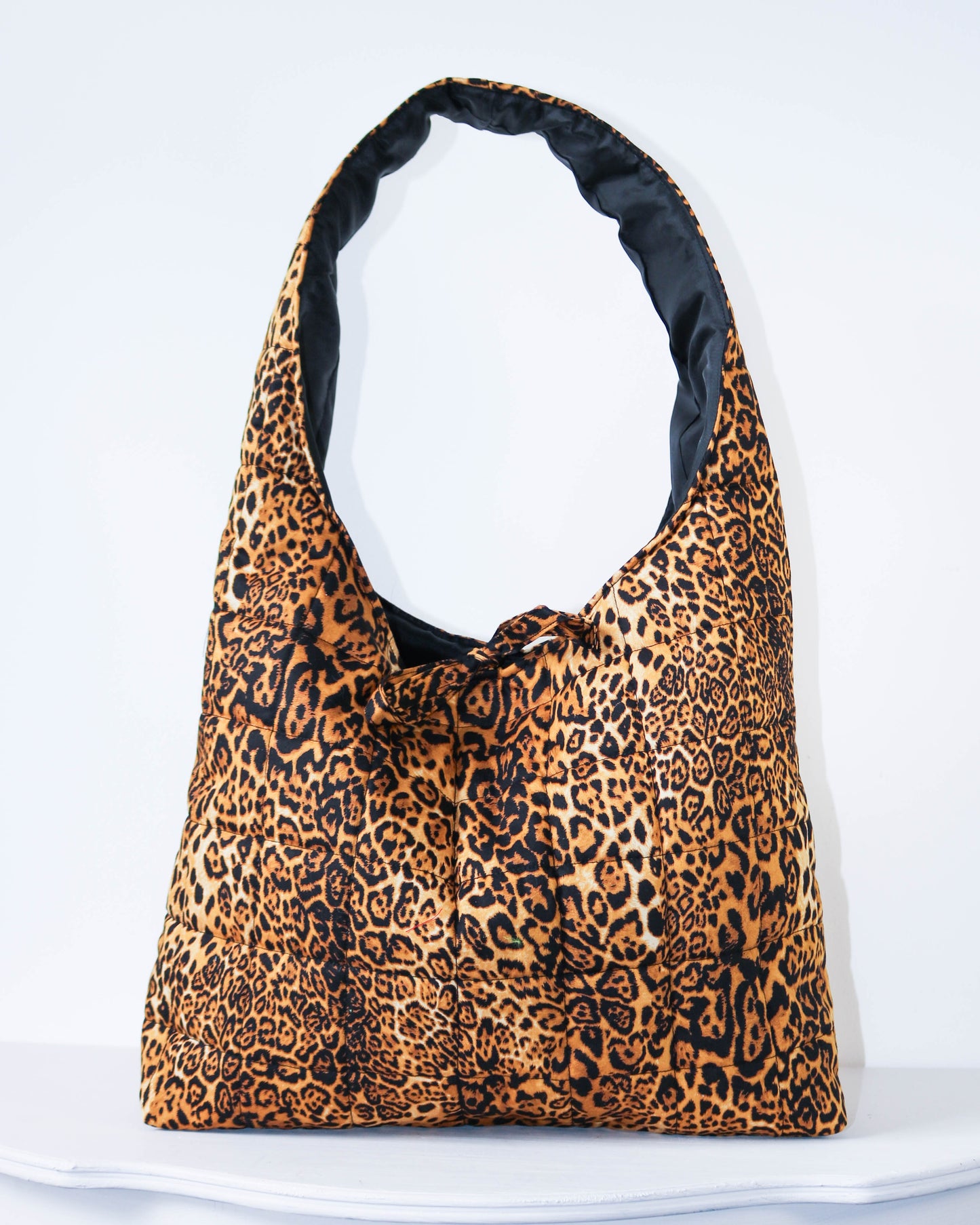 Leopard print bag with black interior on a white background