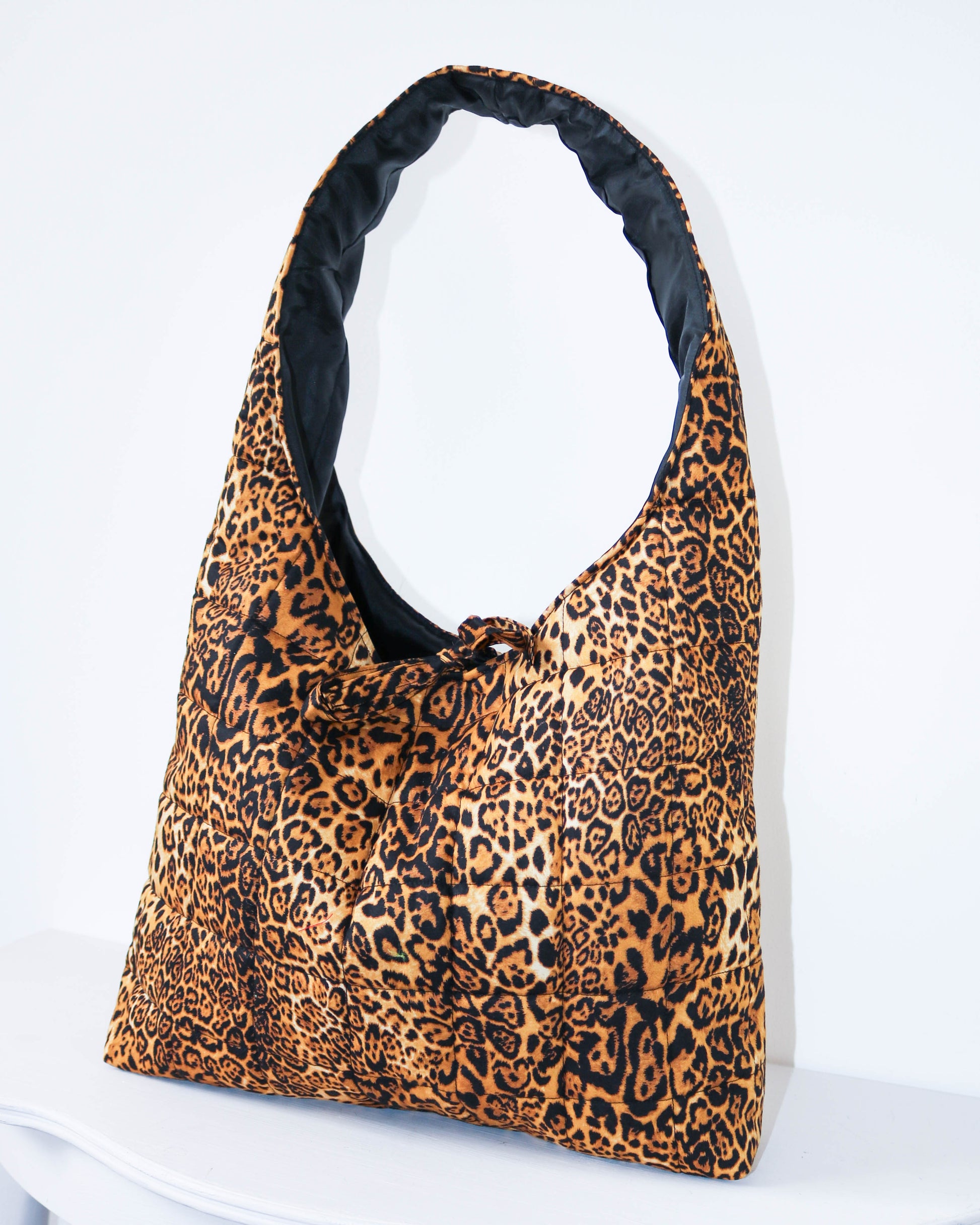 Leopard print bag with black interior on a white background