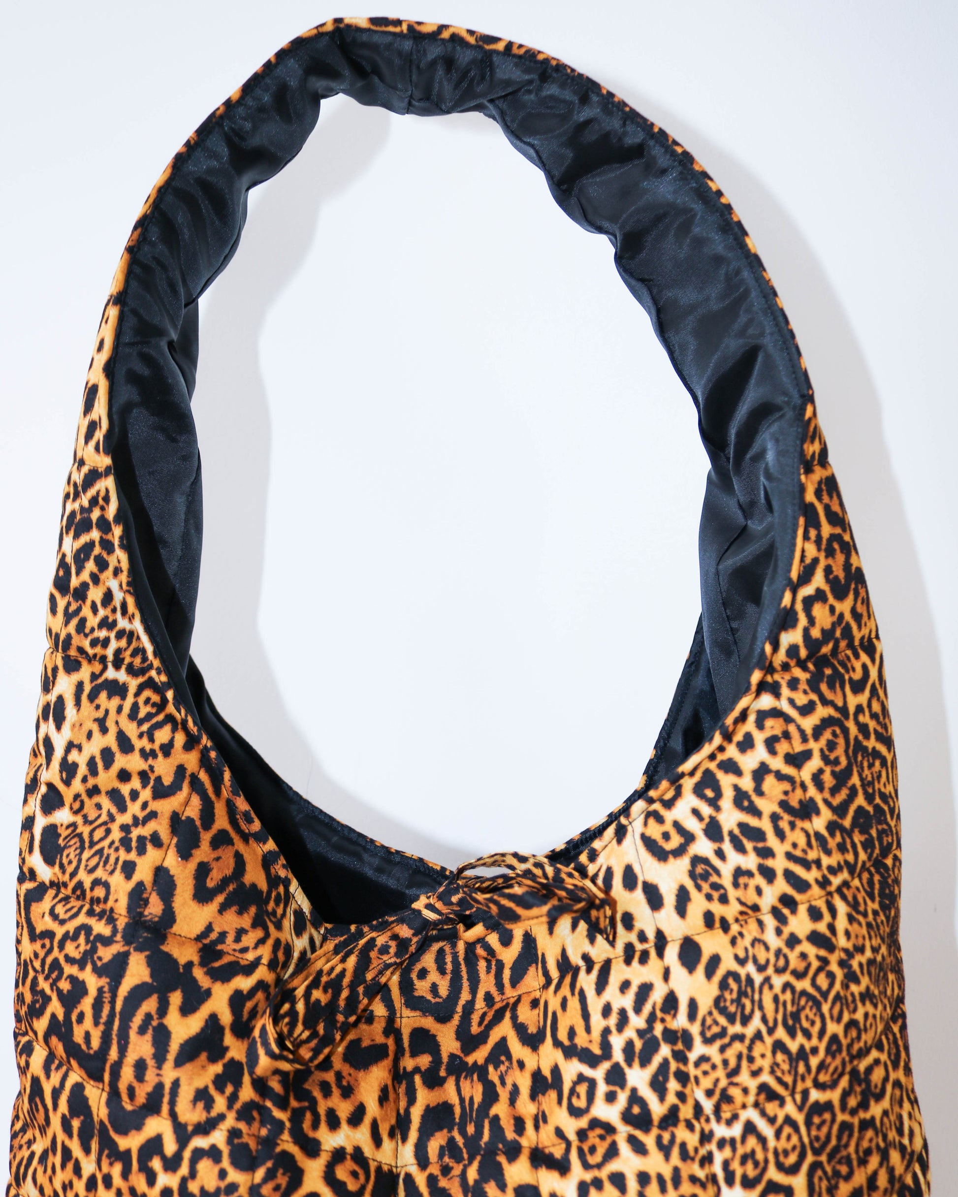Leopard print bag with black interior on a white background