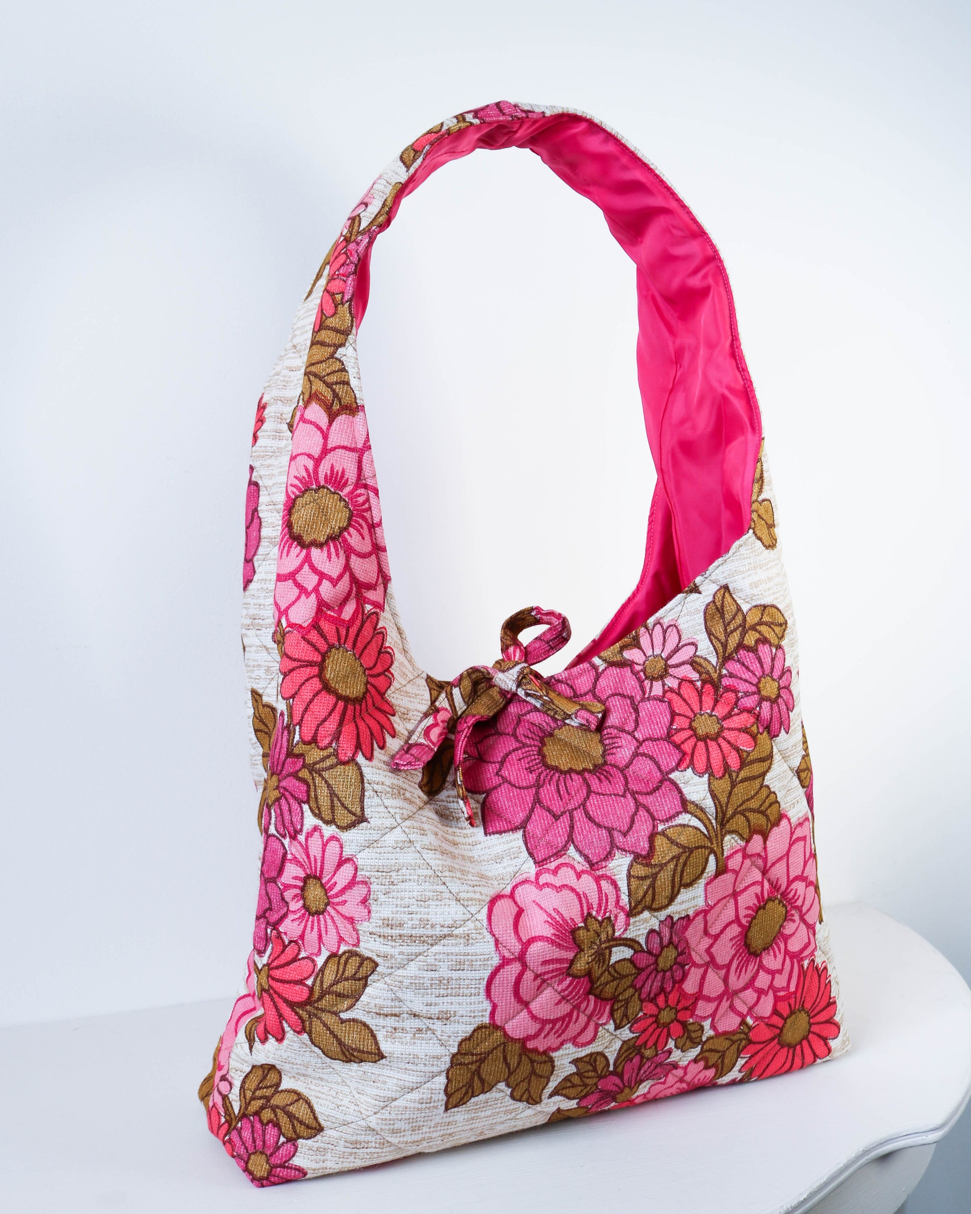 Floral handbag with pink handle on a white background