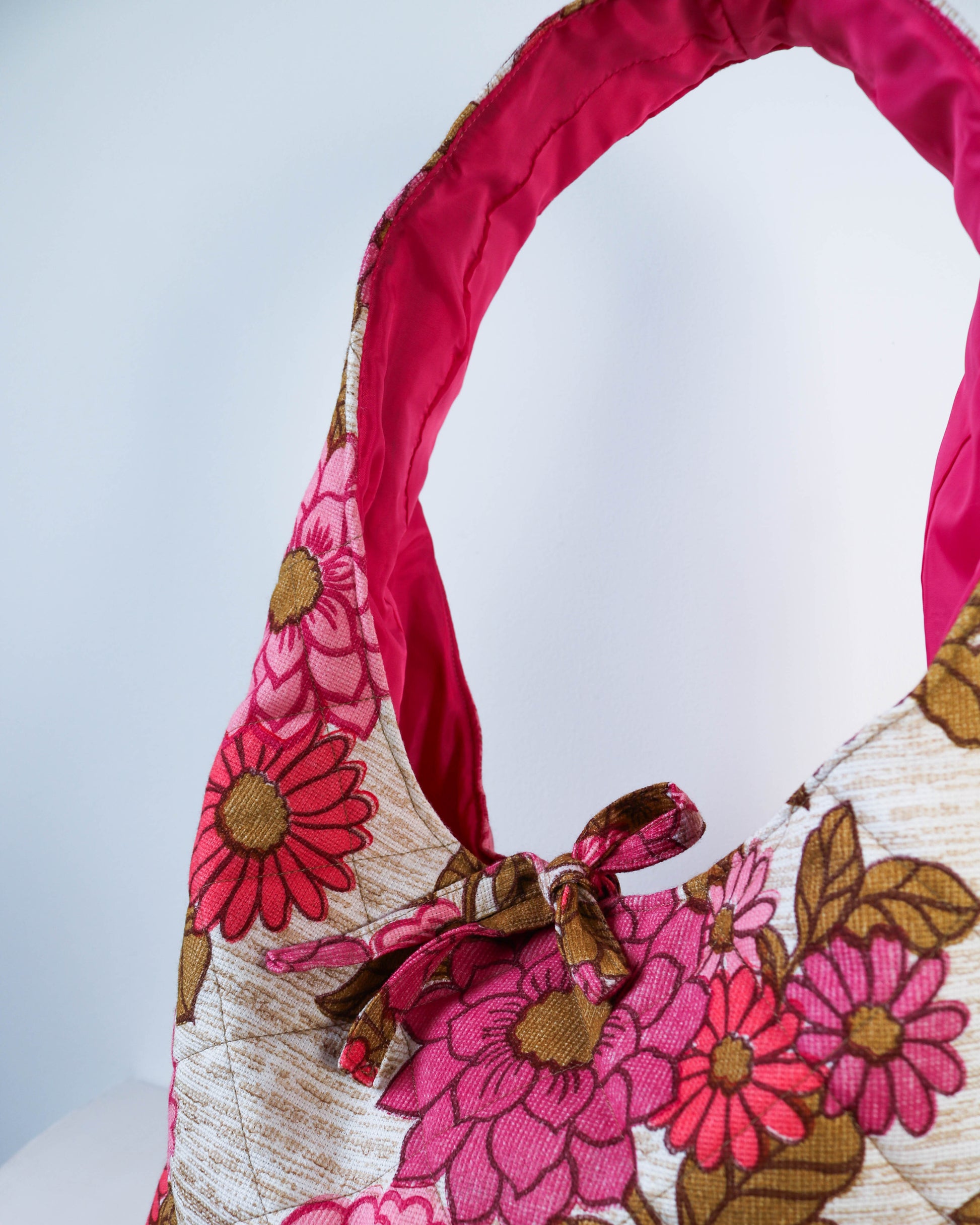 Floral patterned bag with pink and brown colors on a white background