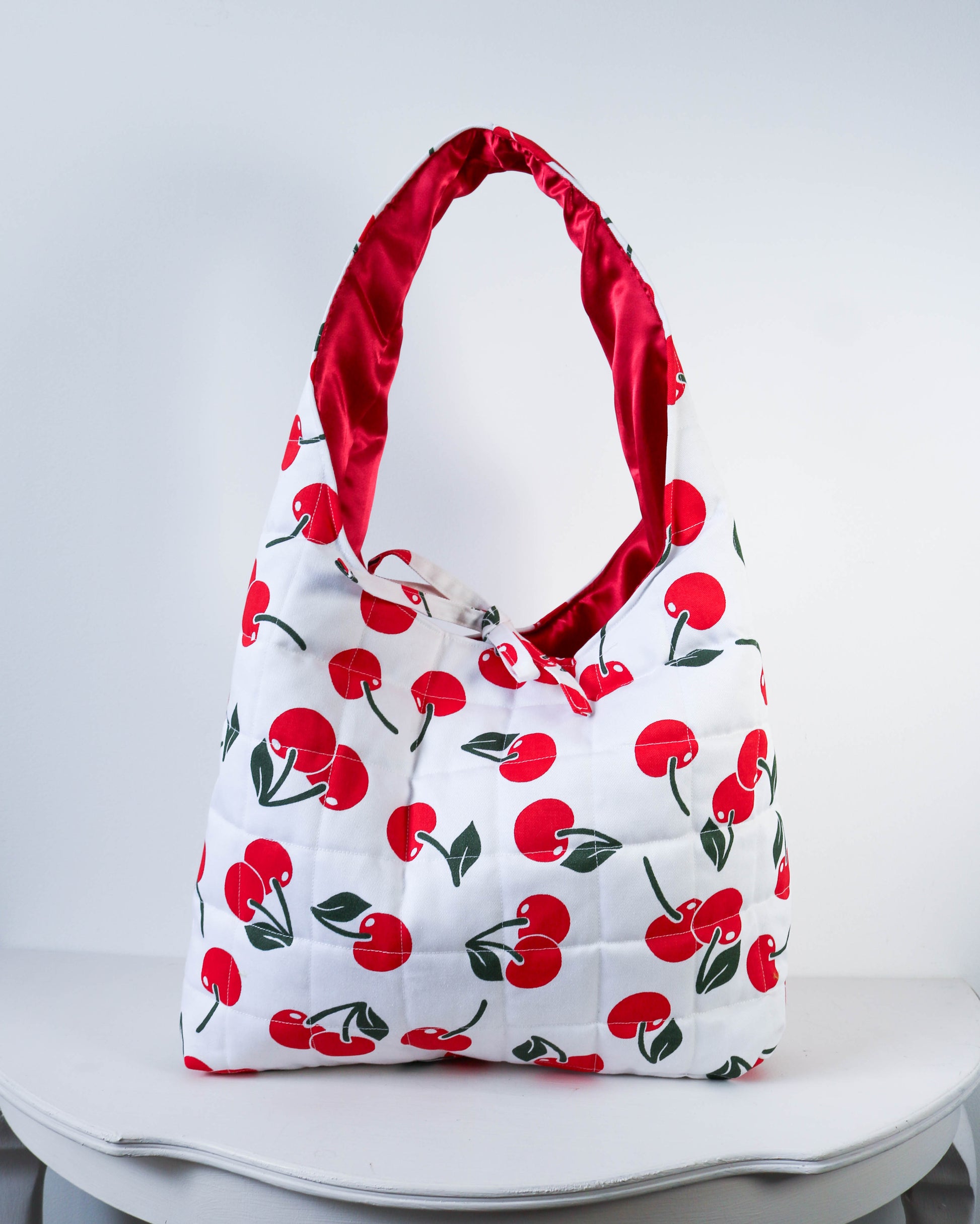 Handbag with cherry pattern on a white background