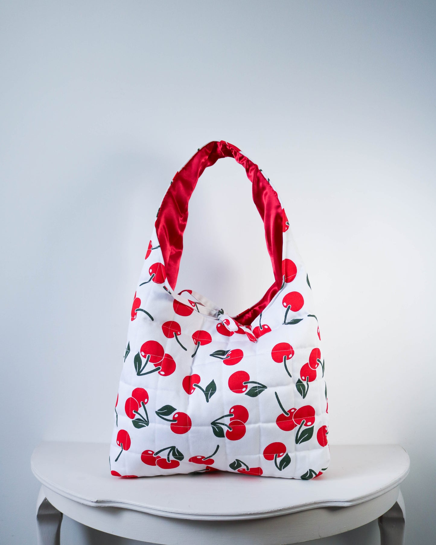 Bag with red cherry pattern on a white background