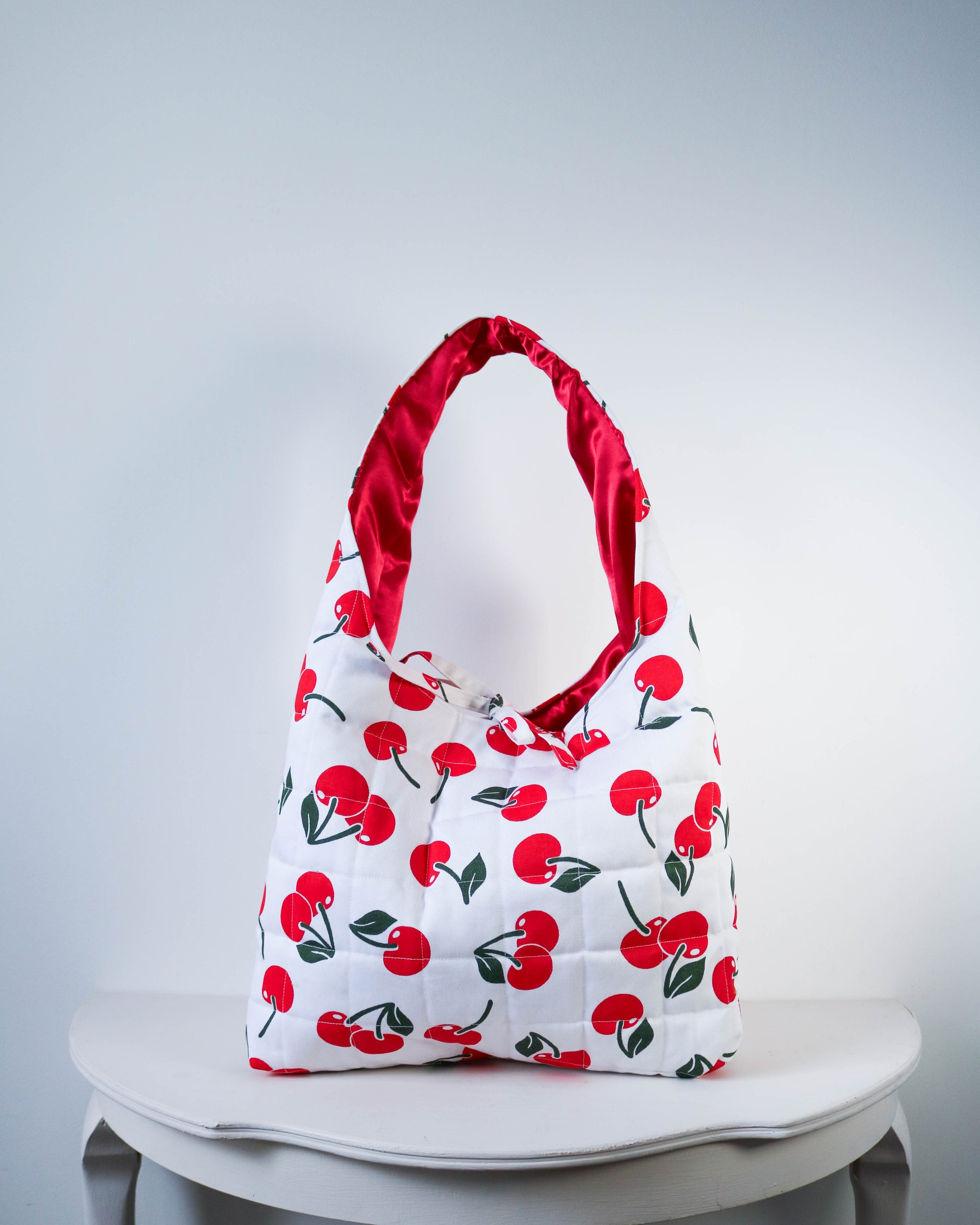 Bag with red cherry pattern on a white background