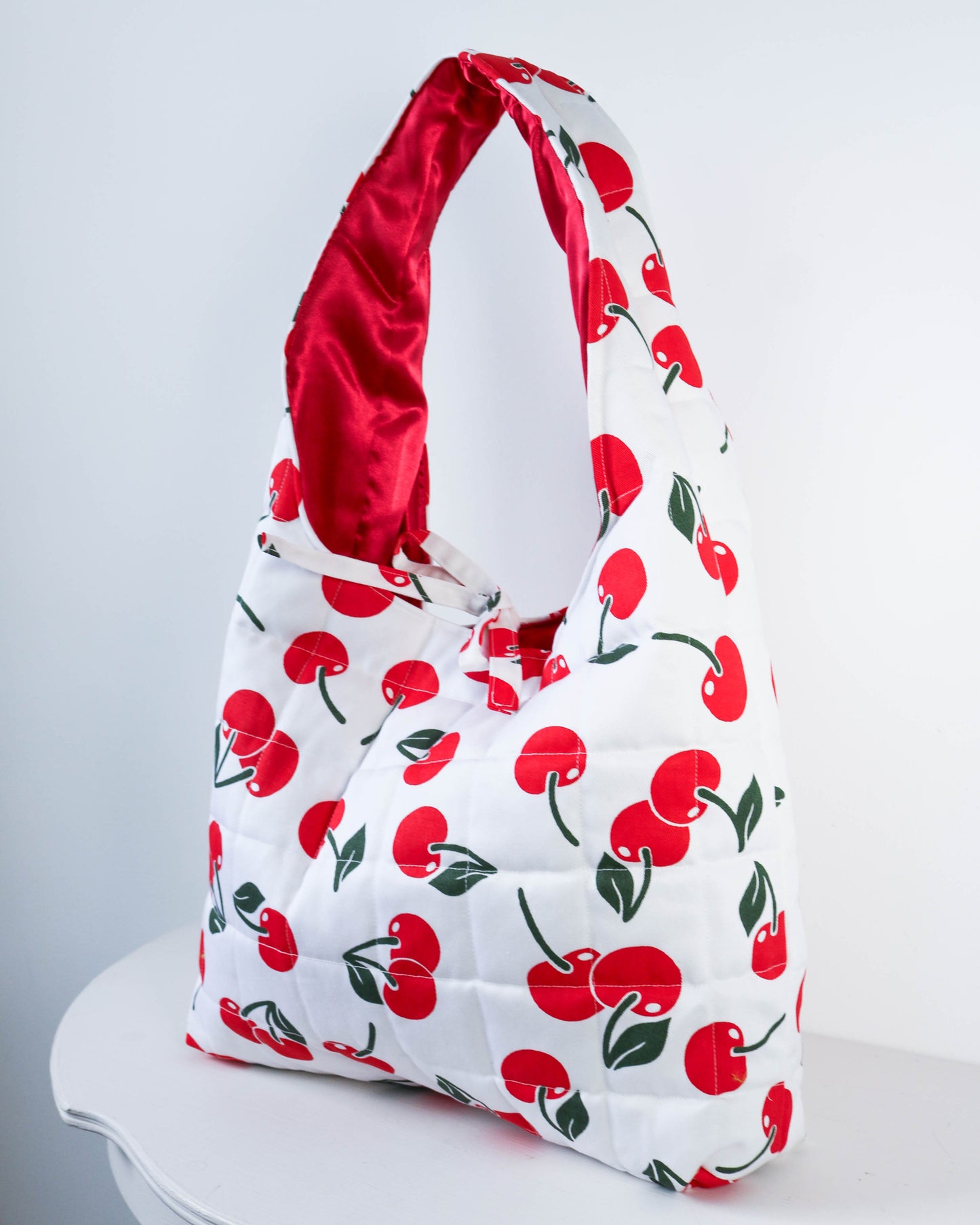 Handbag with cherry pattern on a white background