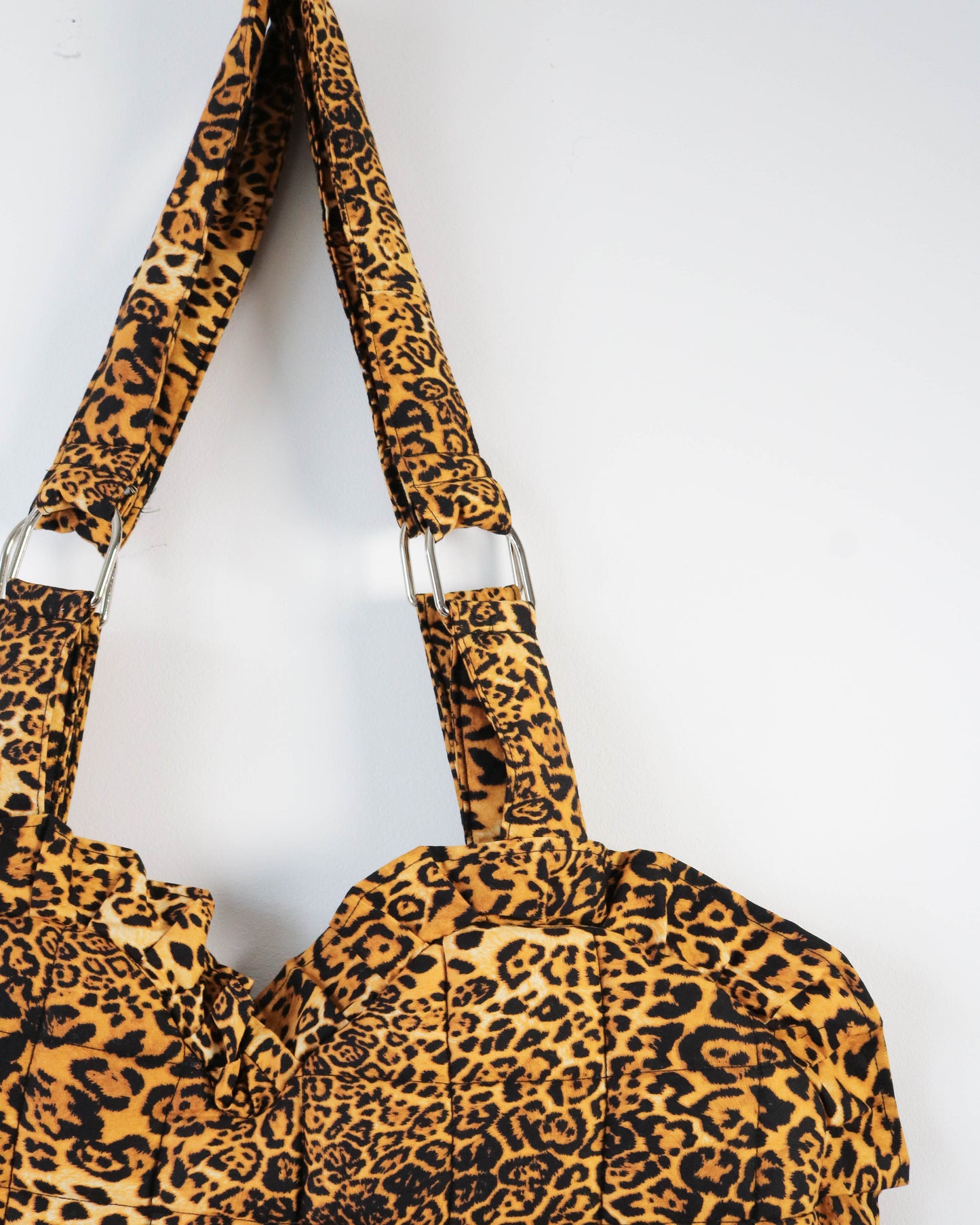 Leopard print bag with matching strap on a white background