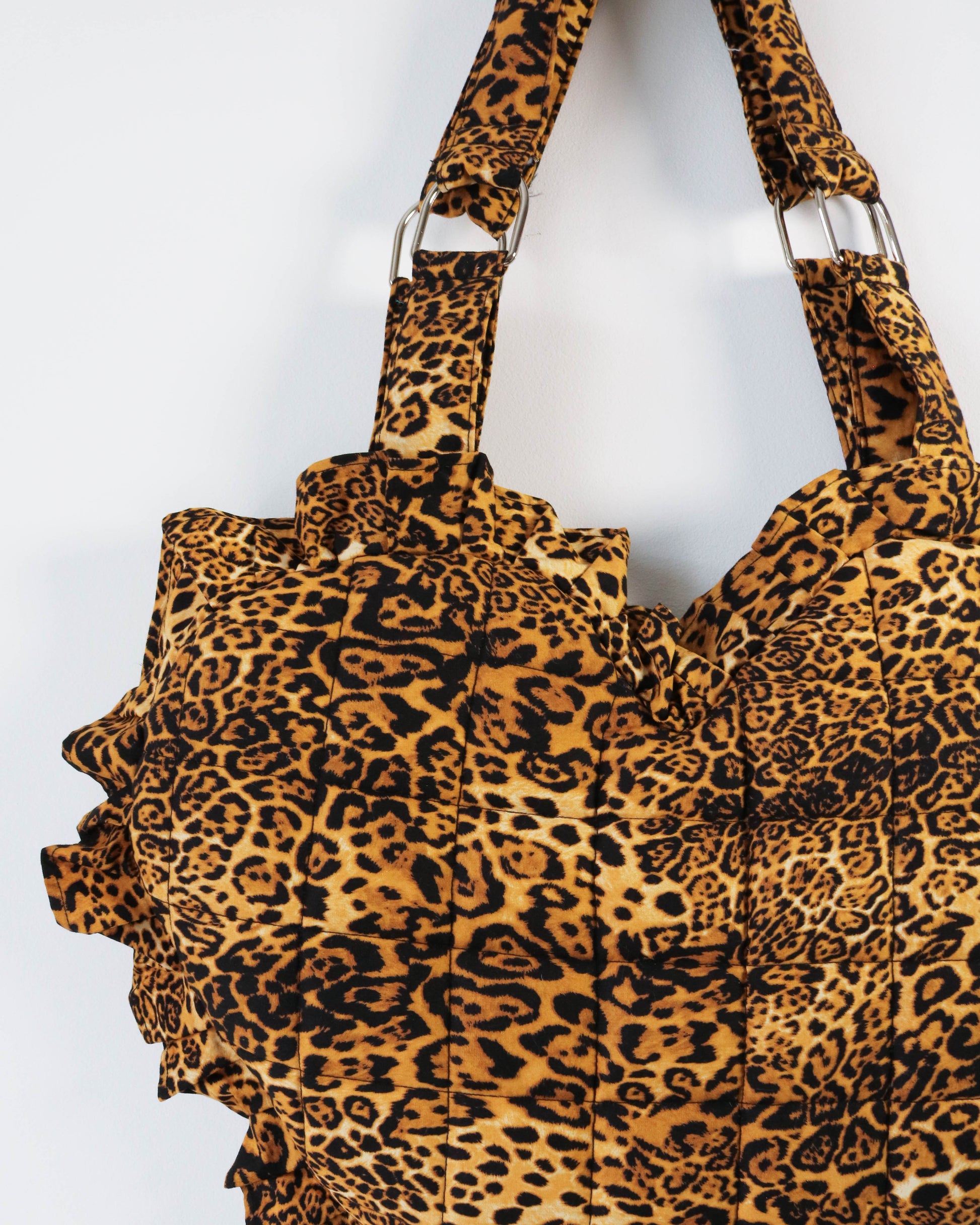 Leopard print tote bag with ruffled details on a white background