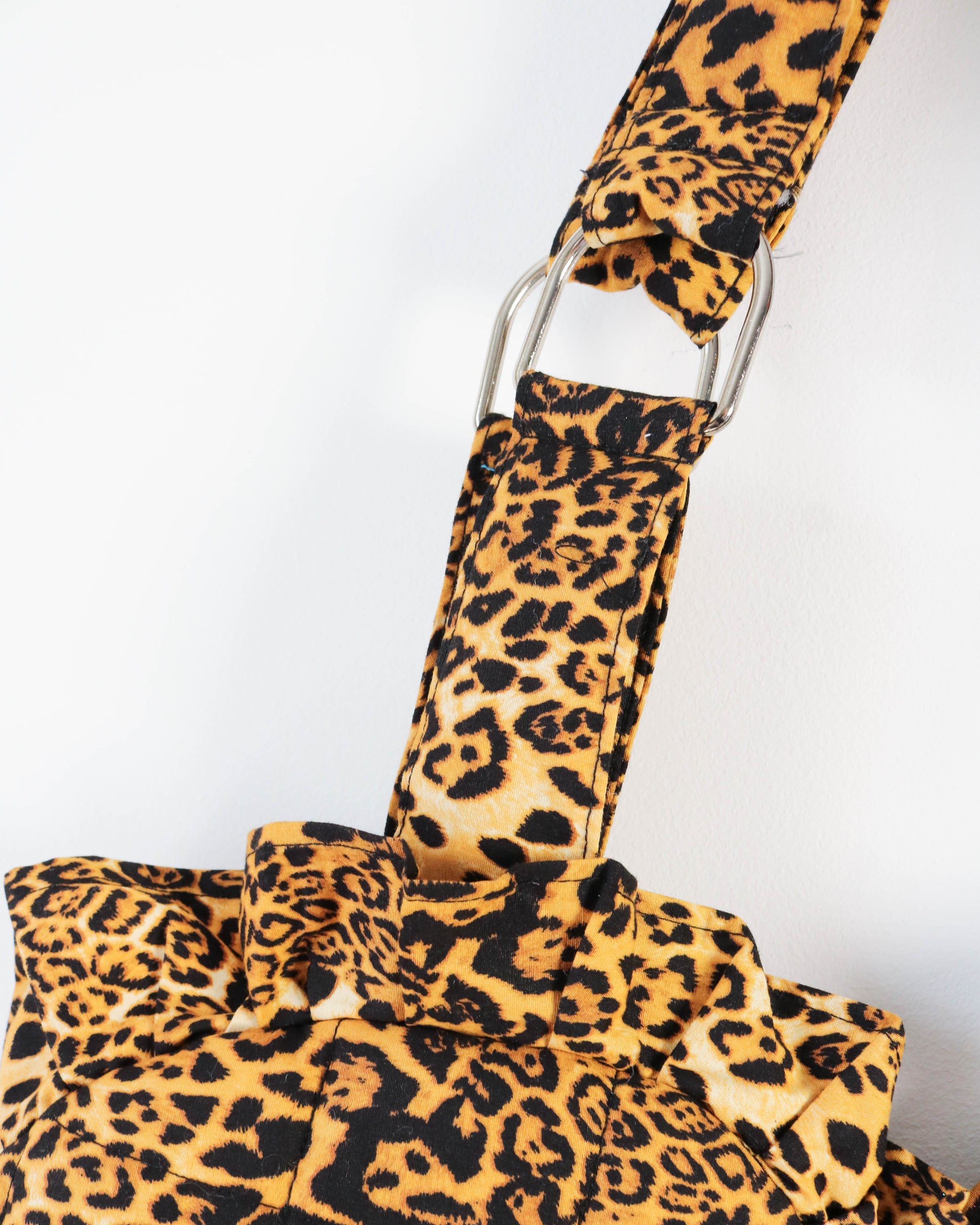 Leopard print bag strap on a white background