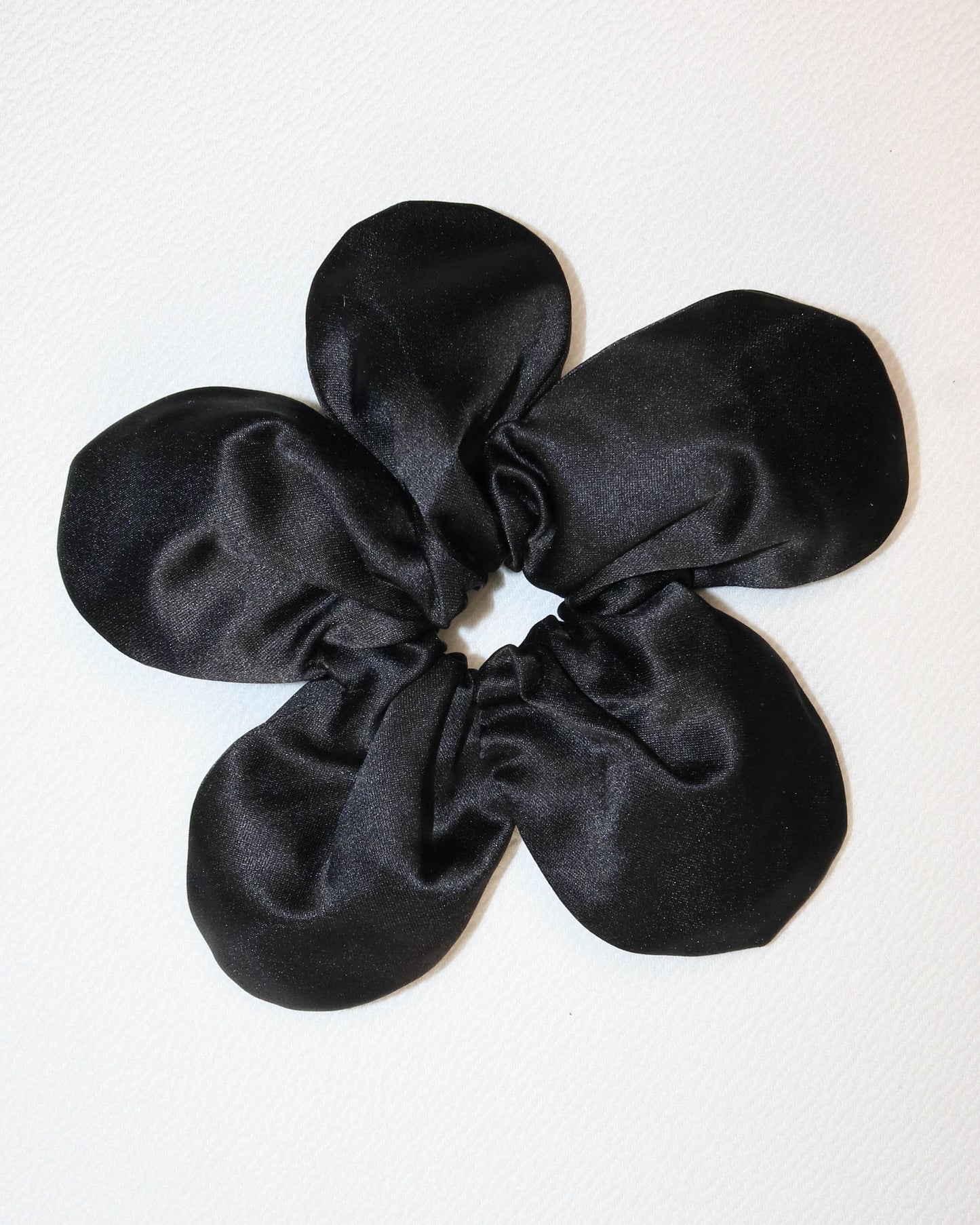 Black satin scrunchie on a white background