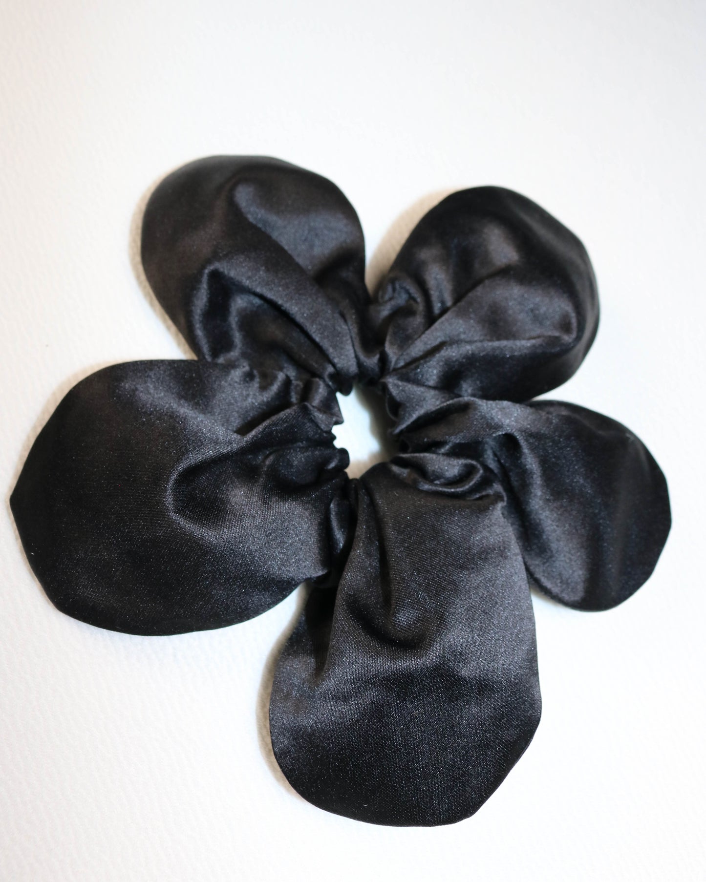 Black satin scrunchie on a white background