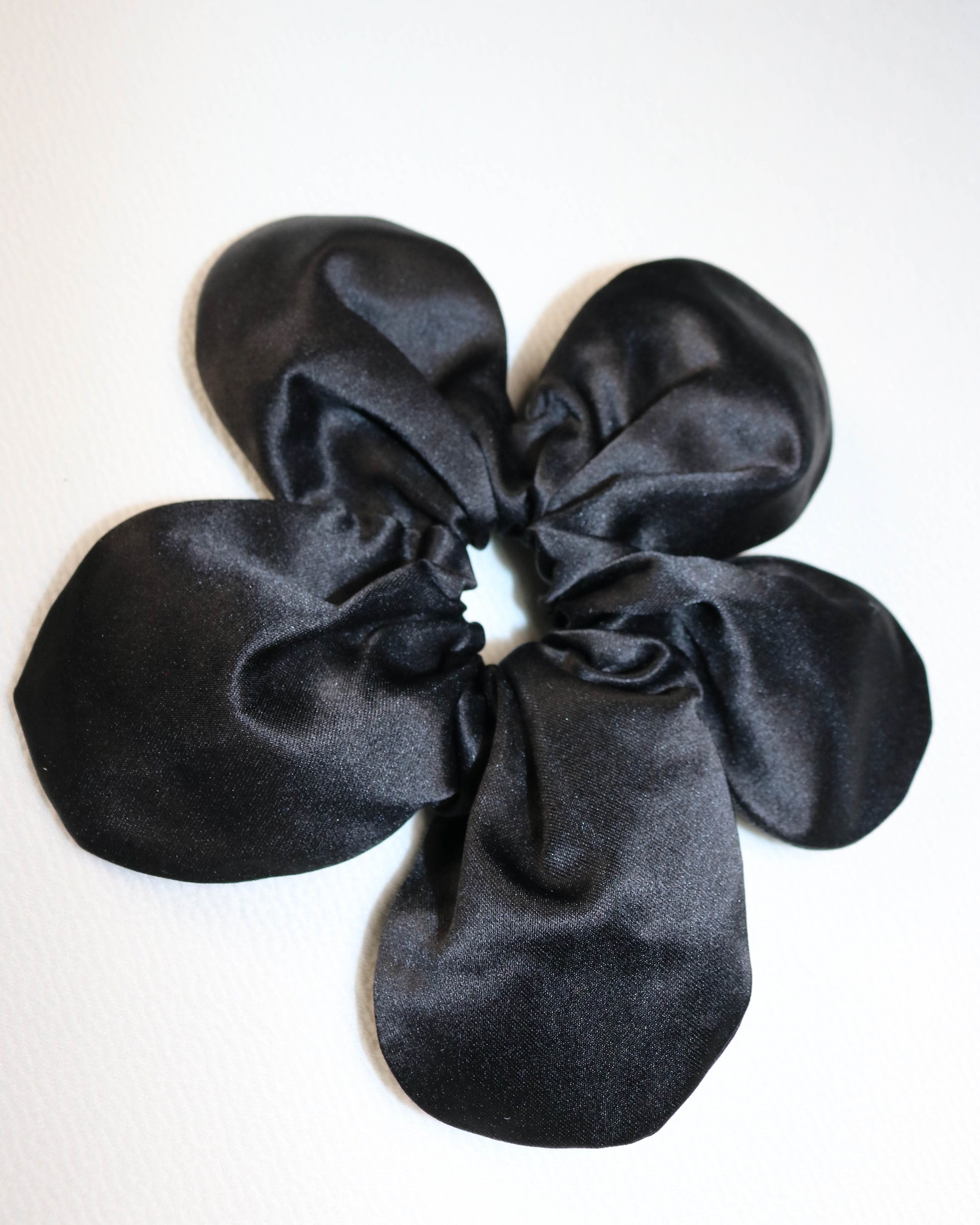Black satin scrunchie on a white background