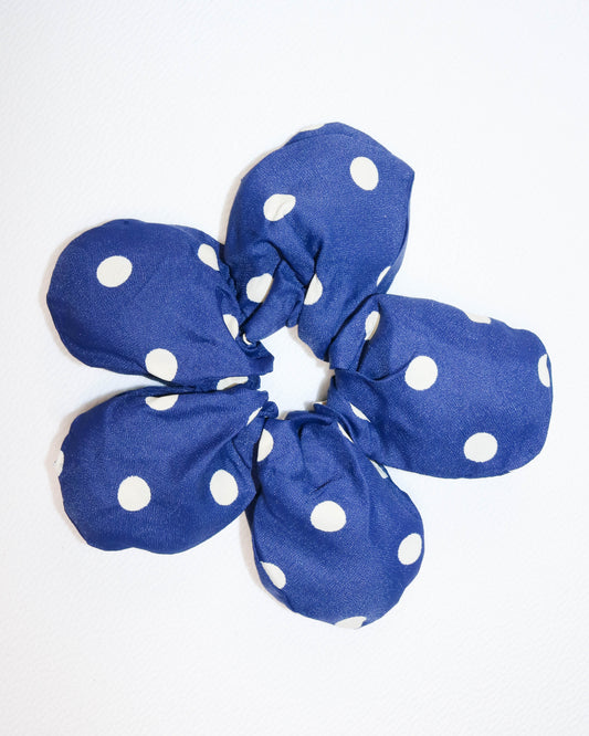 Blue scrunchie with white polka dots on a white background