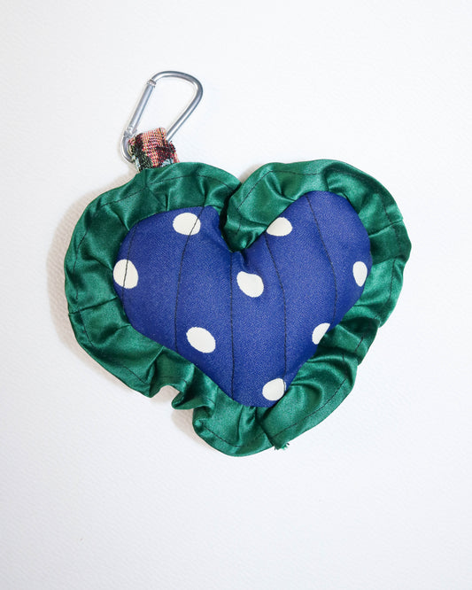 Blue pouch with white polka dots and green trim on a white background