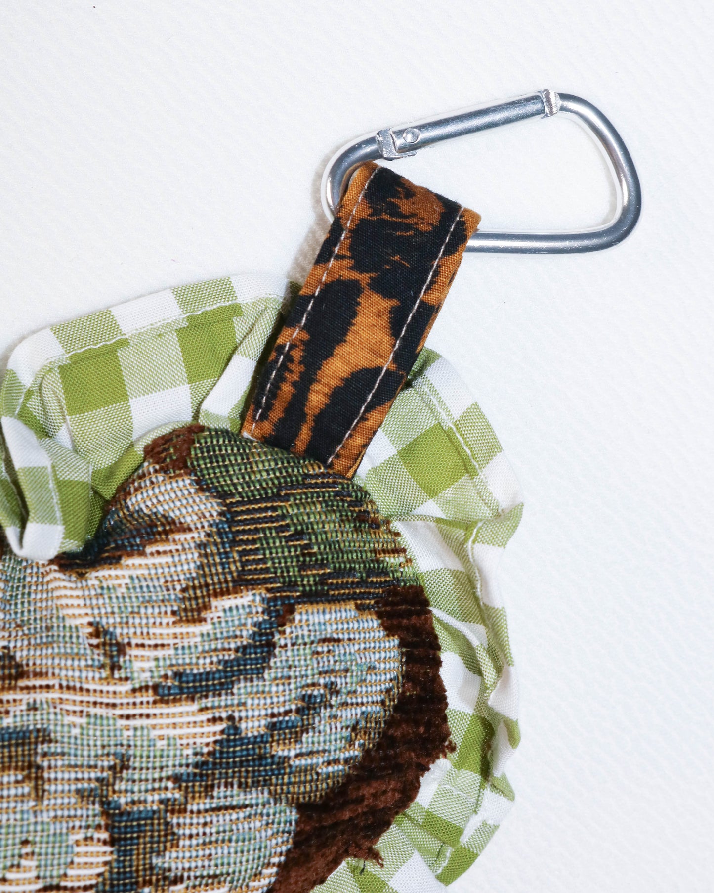 Keychain with leopard print strap and embroidered design on a white background