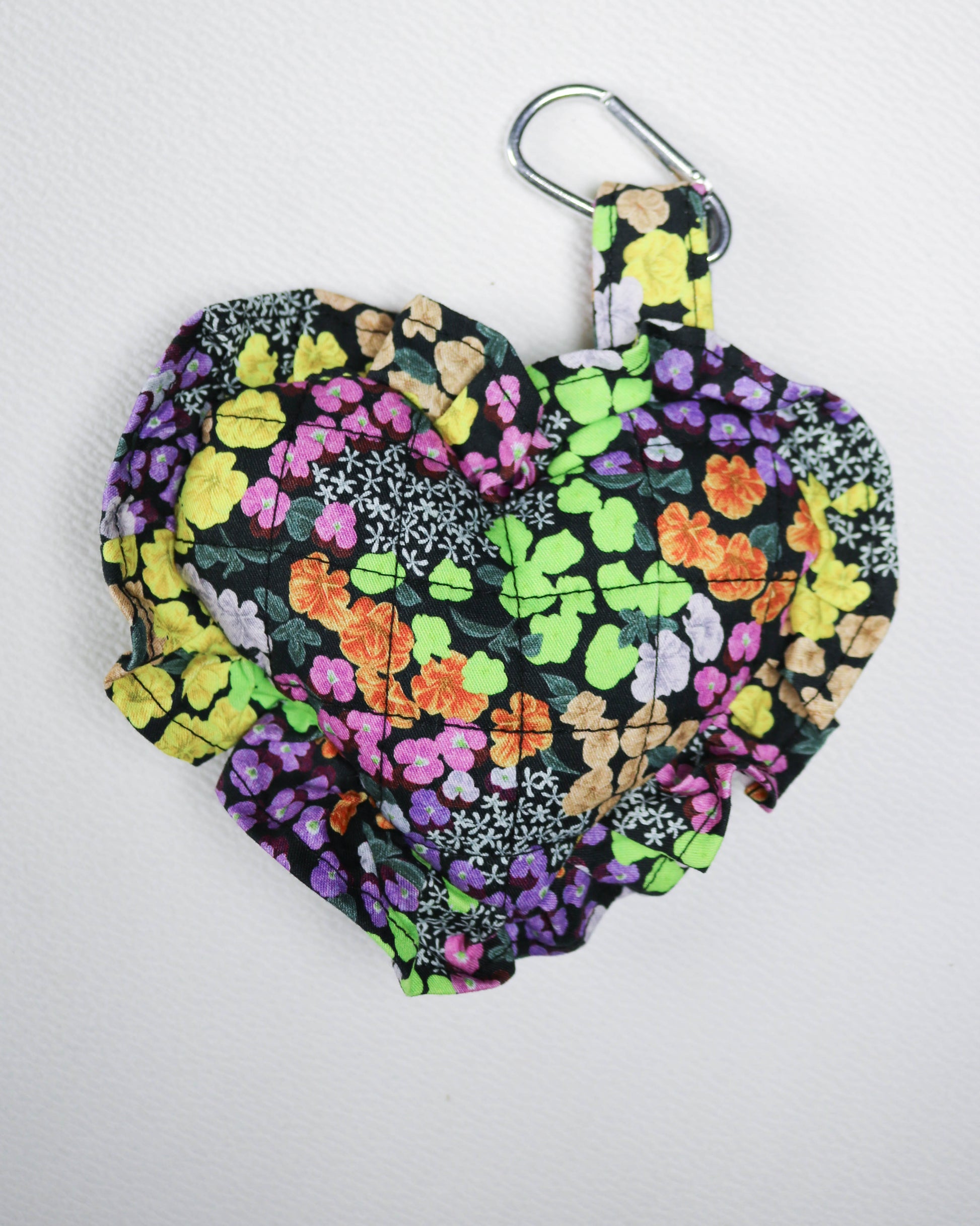 Floral patterned bag with a carabiner on a white background