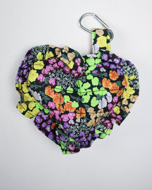 Floral patterned bag with a carabiner on a white background