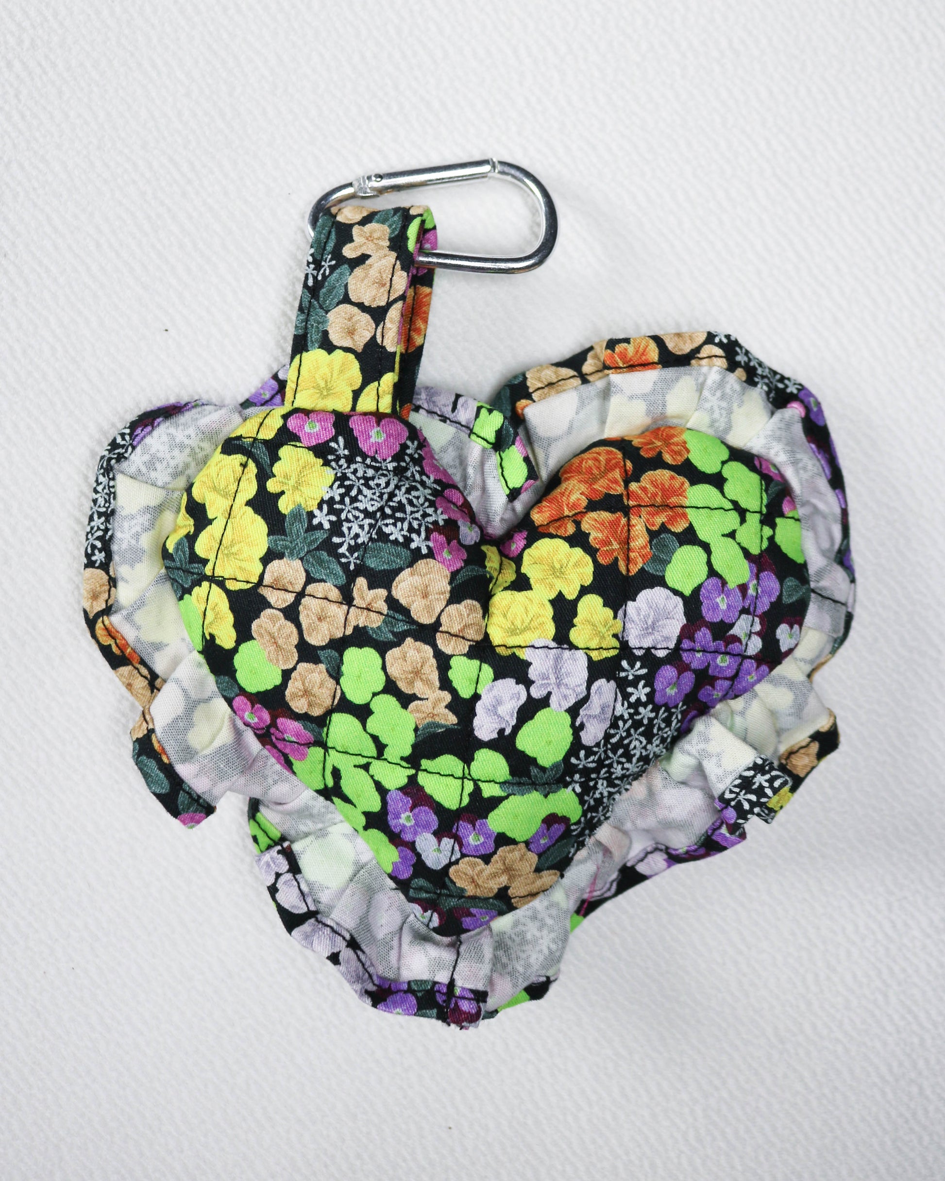 Floral-patterned bag with a carabiner on a white background