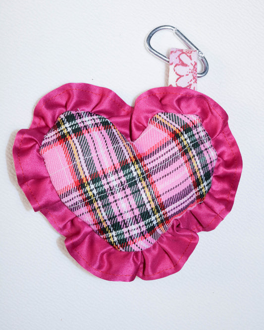 Pink fabric pouch with plaid pattern and carabiner on a white background