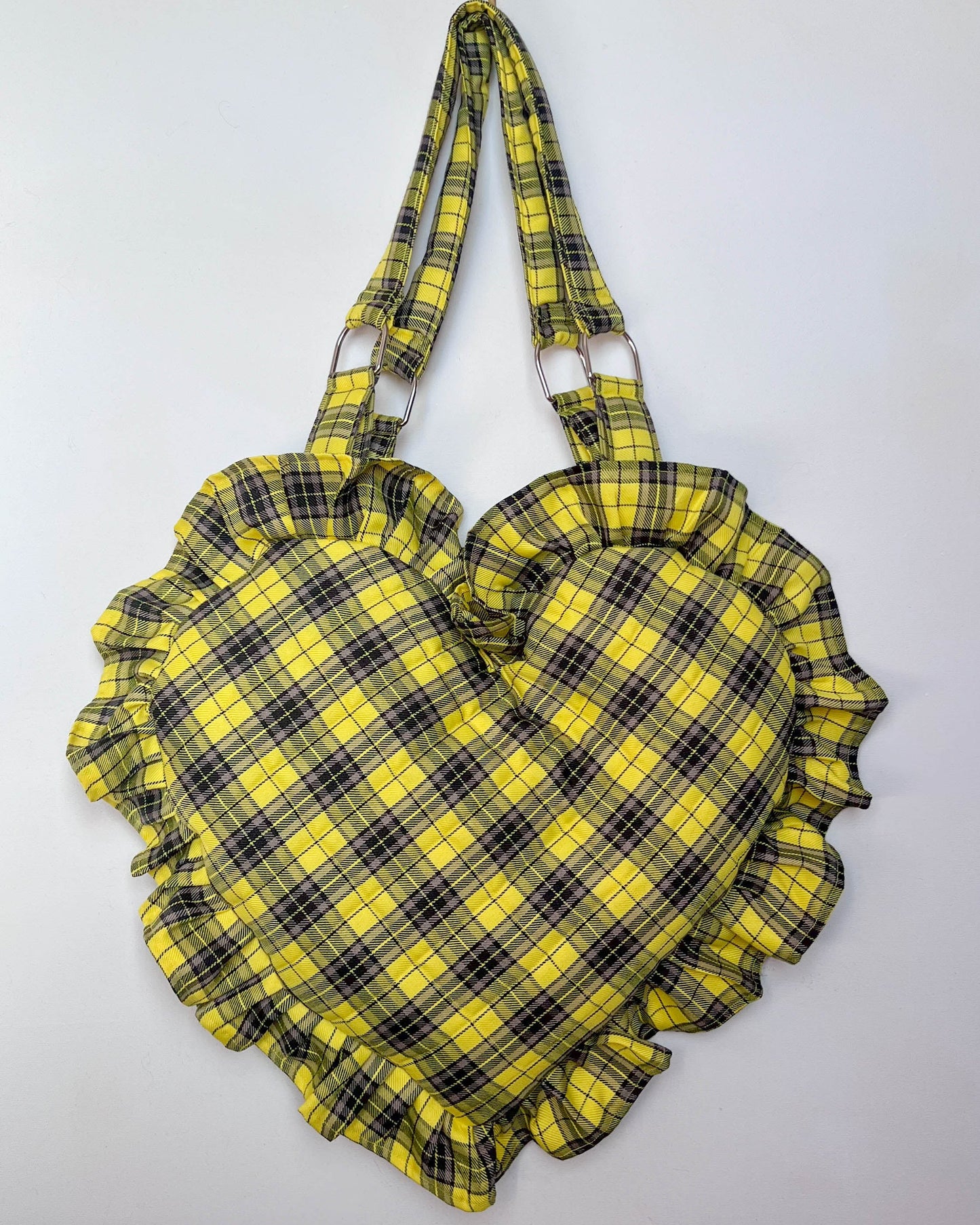 Heart-shaped bag with yellow and black plaid pattern on a white background