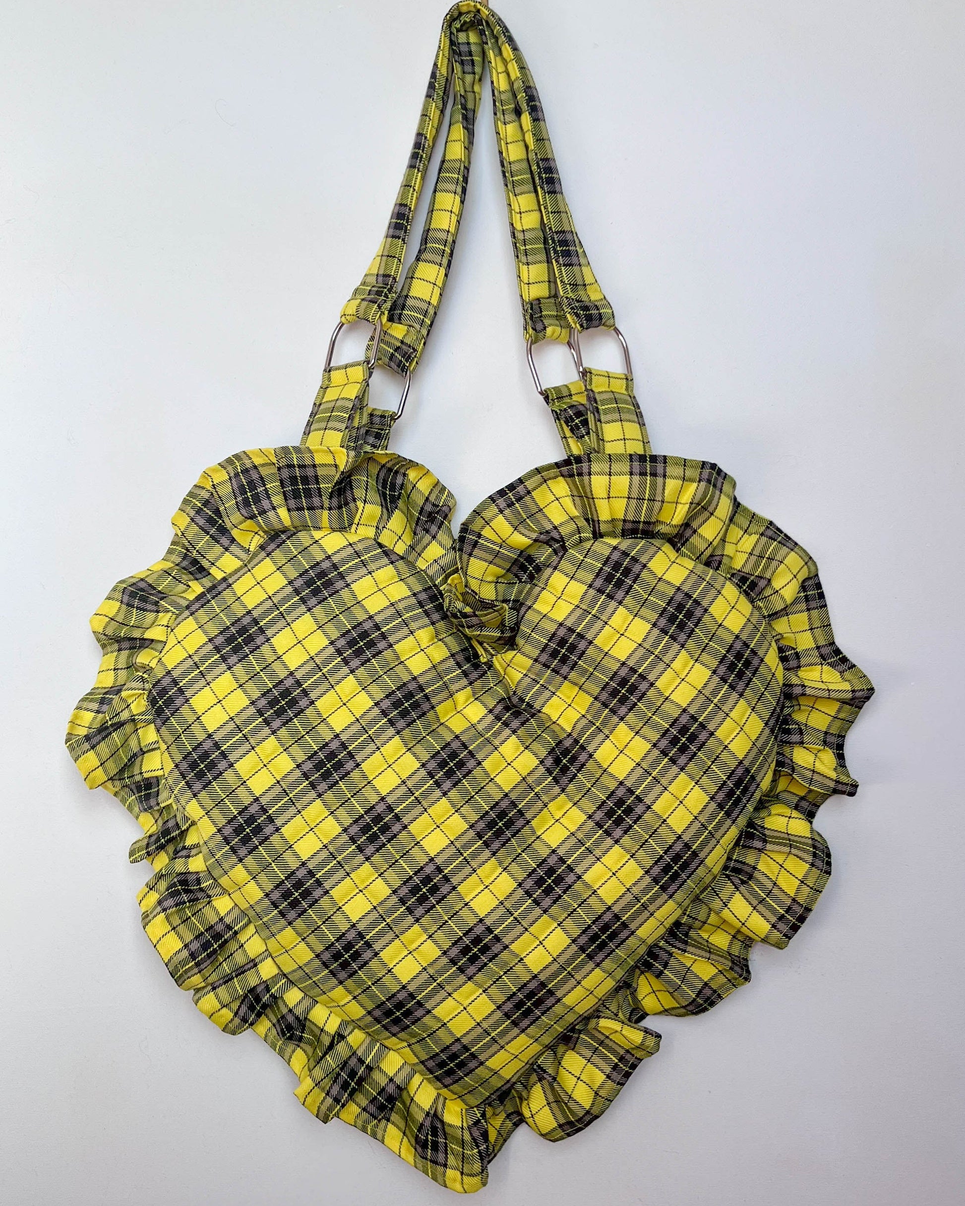 Heart-shaped bag with yellow and black plaid pattern on a white background