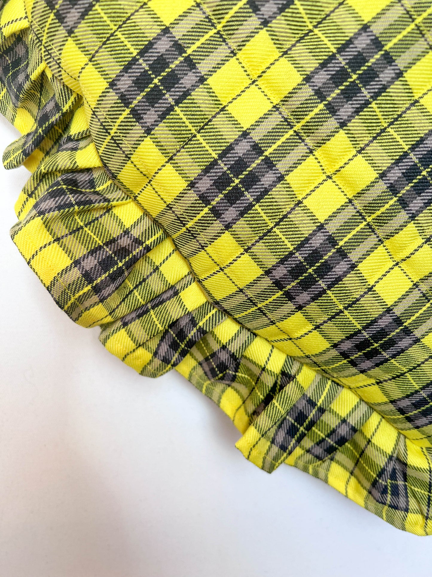 Close-up of yellow and black plaid fabric on a white background