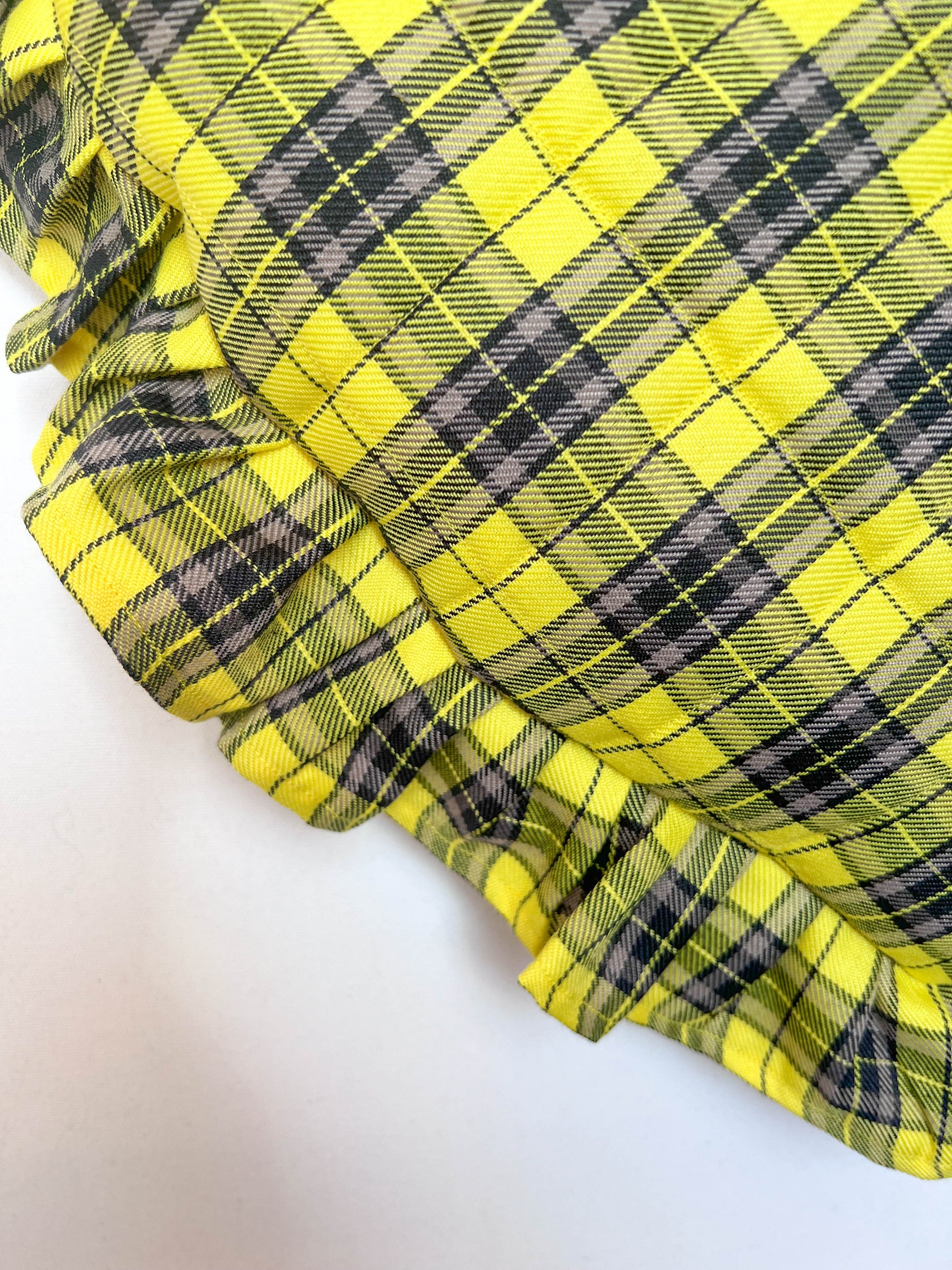 Close-up of yellow and black plaid fabric on a white background